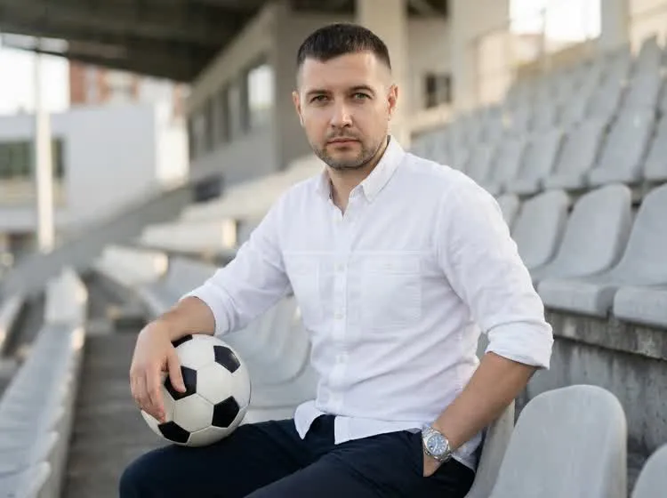 Piotr Bąk, założyciel Kitzo, na trybunach stadionu z piłką